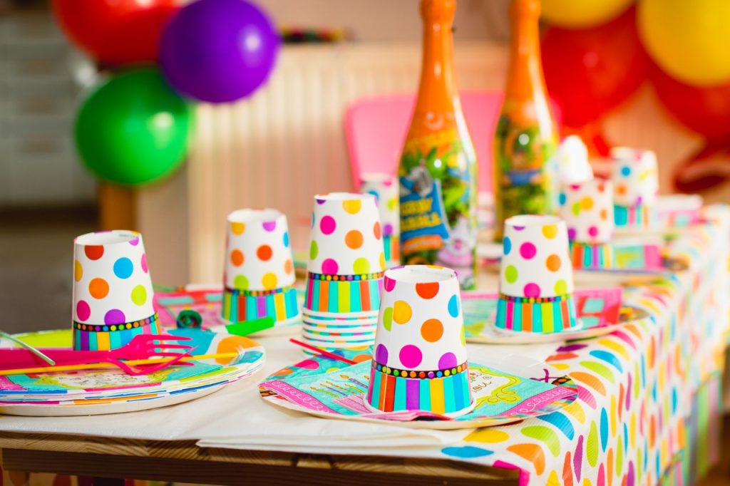 Colorful party table setup with polka dot cups and balloons, perfect for celebrations.